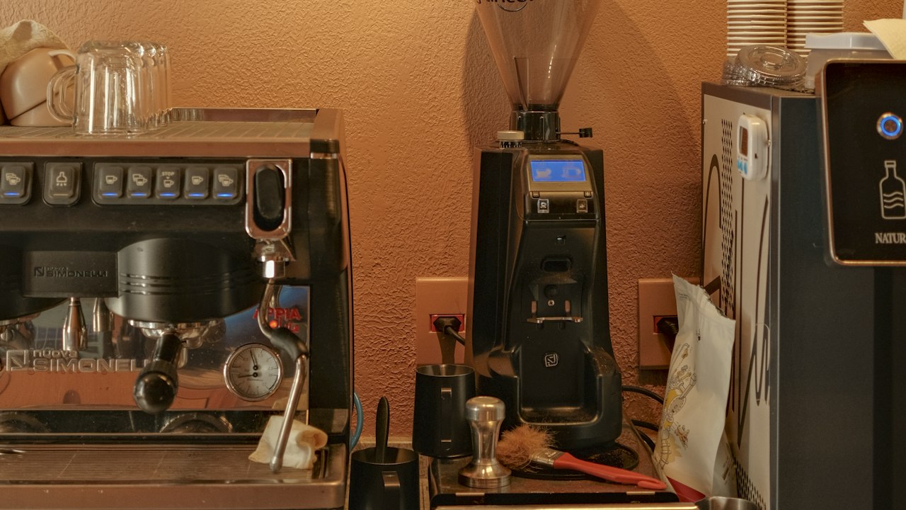 A coffee shop counter with a menu and an espresso machine
